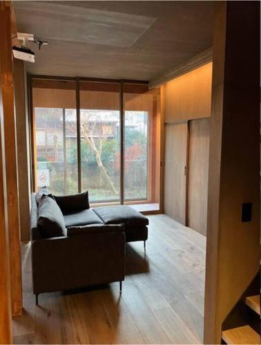 a living room with a couch and a large window at unito 逗子別邸 in Zushi