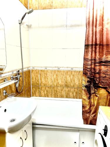 baño con lavabo y cortina de ducha en Двухкомнатная квартира в центре, en Semey