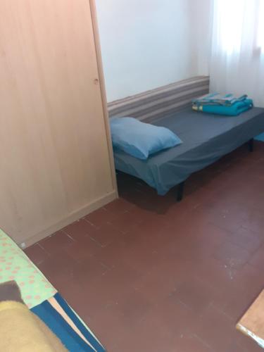 Cette petite chambre comprend un lit et une porte. dans l'établissement Dortoirs Hommes, à Béziers