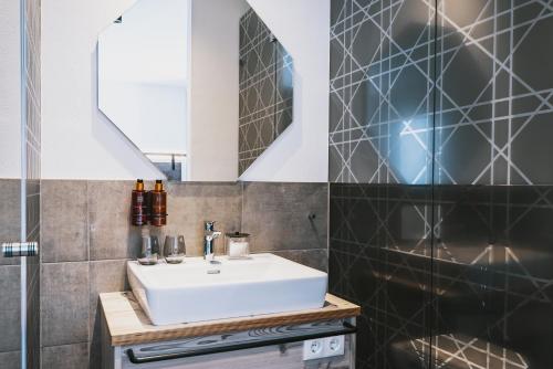 a bathroom with a sink and a mirror at Nikolaus by AvenidA Panoramic Wellness Suites in Zell am See
