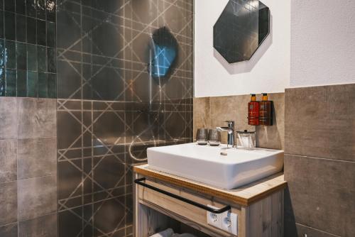 a bathroom with a sink and a shower at Nikolaus by AvenidA Panoramic Wellness Suites in Zell am See