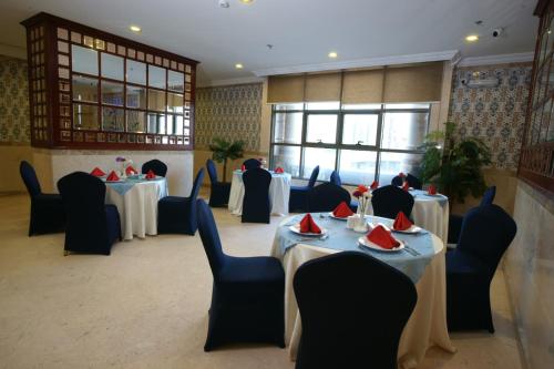 メッカにあるفندق قصر الأزهر - Qasr AL Azhar Hotelのダイニングルーム(テーブル、椅子、テーブルトップ付)
