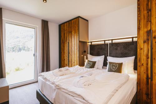 a bedroom with a large bed with towels on it at Nikolaus by AvenidA Panoramic Wellness Suites in Zell am See