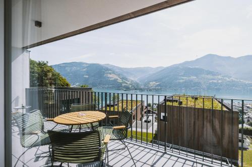 a balcony with a table and chairs and a view of the mountains at Nikolaus by AvenidA Panoramic Wellness Suites in Zell am See