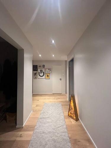 - un couloir avec une chambre blanche dotée d'un tapis et d'une lumière dans l'établissement Vaasa central apartment, à Vaasa