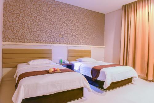 a hotel room with two beds with fruit on a tray at Sahid T-More Hotel in Kupang