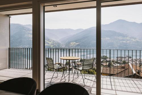 a balcony with a table and chairs and mountains at Nikolaus by AvenidA Panoramic Wellness Suites in Zell am See