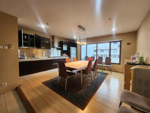 a kitchen and dining room with a table and chairs at Penthouse Grand Setiabudi Apartment Bandung in Bandung