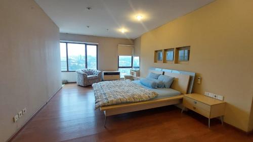 a bedroom with a large bed with blue pillows at Penthouse Grand Setiabudi Apartment Bandung in Bandung