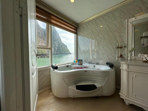 uma banheira na casa de banho com uma grande janela em Halong AQUAR CRUISE em Ha Long
