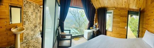 a bedroom with a bed and a large window at Catcat Garden House in Sa Pa