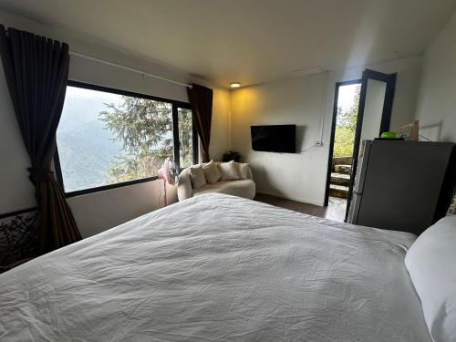 a bedroom with a large bed and a large window at Catcat Garden House in Sa Pa