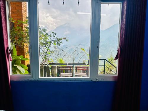an open window with a view of a balcony at Catcat Garden House in Sa Pa