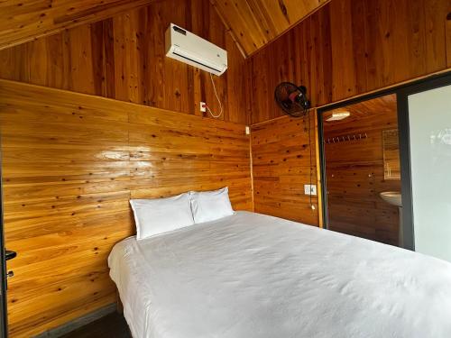 a bedroom with a bed in a wooden wall at Catcat Garden House in Sa Pa