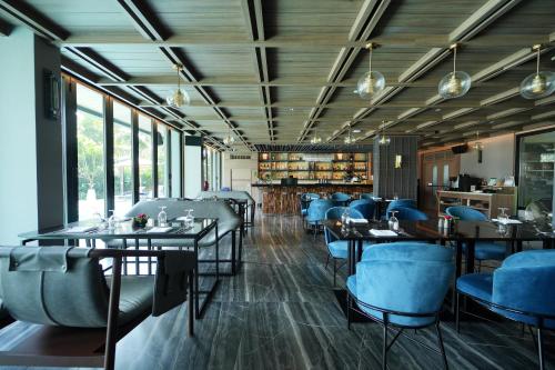 a dining room with tables and blue chairs at Ten Six Hundred, Chao Phraya, Bangkok by Preference, managed by The Ascott Limited in Bangkok