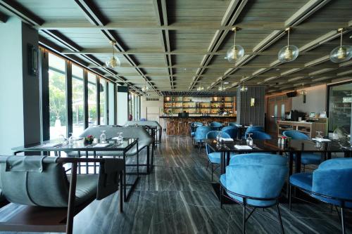 un comedor con mesas y sillas azules en Ten Six Hundred, Chao Phraya, Bangkok by Preference, managed by The Ascott Limited en Bangkok