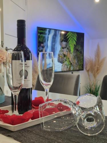 a bottle of wine and two glasses on a table at Luxury Apartment Megy in Otočac