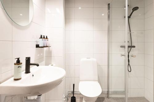 a white bathroom with a sink and a shower at Playhotel in Mjölby