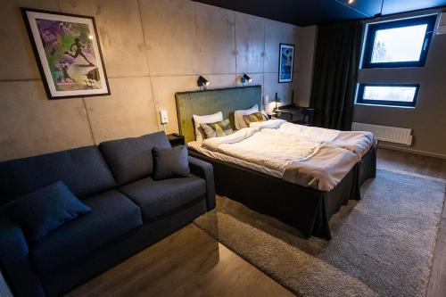 um quarto com uma cama e um sofá em Playhotel em Mjölby