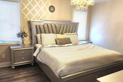 sypialnia z dużym łóżkiem z poduszkami i żyrandolem w obiekcie Perfect Family Home w mieście Collins Bay