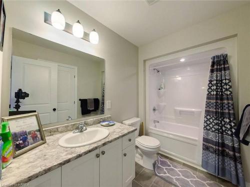 W łazience znajduje się umywalka, toaleta i lustro. w obiekcie Perfect Family Home w mieście Collins Bay