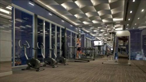 - une salle de sport avec des rangées d'équipements d'exercice dans un bâtiment dans l'établissement Apartament Bangkok - On Nut, à Bangkok