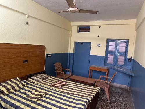 a bedroom with a bed and a blue wall at Navata Lodge in Pulivendla