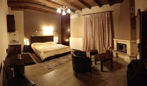a bedroom with a bed and a table and a fireplace at Hotel Edem in Kato Loutraki