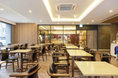 a restaurant with tables and chairs in a room at Browndot Suwon cityhall in Suwon