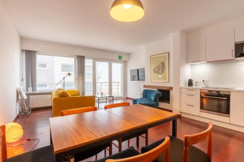 Il comprend une cuisine et un salon avec une table et des chaises. dans l'établissement SeaView with style, à Ostende