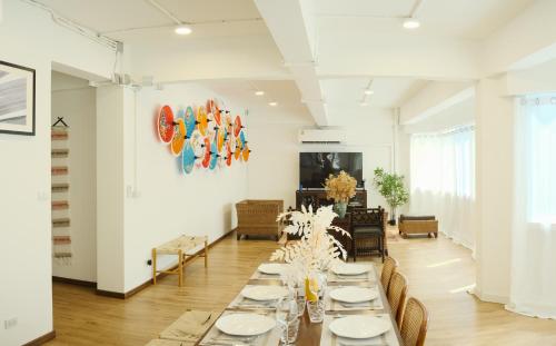 un comedor largo con mesas y sillas blancas en Private Full-Floor Spacious 5BR in China Town, en Bangkok
