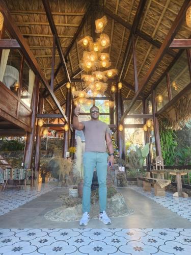 a man standing in front of a building at Pu Luong Paradise in Hương Bá Thước