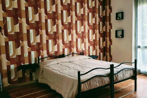 a bedroom with a bed and a wall with a pattern at Flat 15km Airport Milan BGY in Cologno al Serio