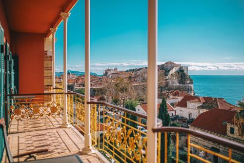 a balcony with a view of the city and the ocean at Hilton Imperial Dubrovnik in Dubrovnik