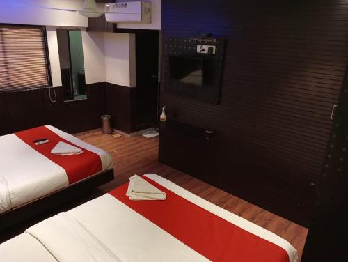 a hotel room with two beds and a door at Terminus Square in Kurla