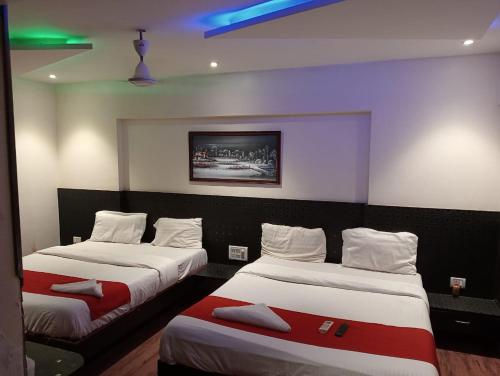 a room with two beds and a painting on the wall at Terminus Square in Kurla