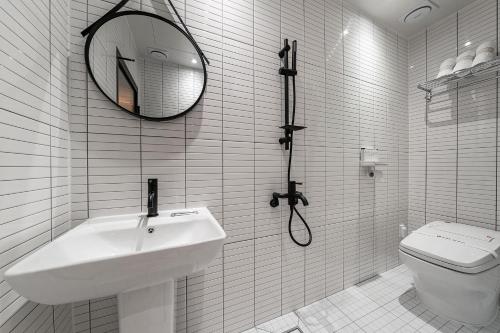 a white bathroom with a sink and a toilet at Browndot Suwon cityhall in Suwon