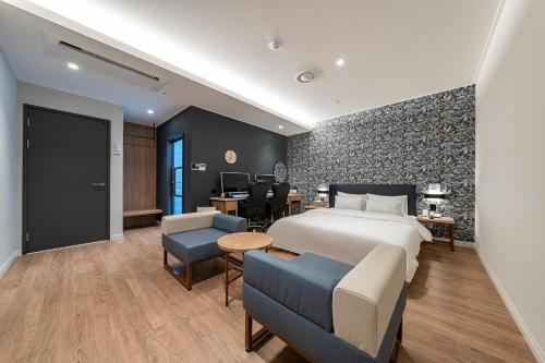 スウォンにあるBrowndot Suwon cityhallのベッドとデスクが備わるホテルルームです。
