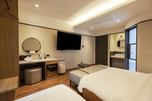 a bedroom with a bed and a sink and a mirror at Browndot Suwon cityhall in Suwon