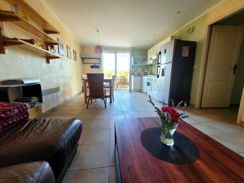un salon avec un vase de fleurs sur une table dans l'établissement Gîte Le Bel-Estar, à Bélesta