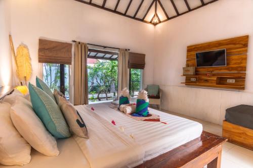 two babies sitting on a large bed in a room at Bale Sampan Boutique Bungalows in Gili Trawangan