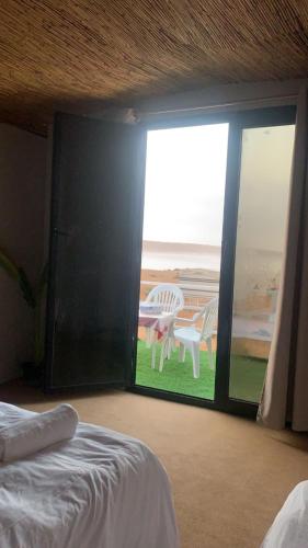 a bedroom with a sliding glass door with a table and chairs at Royal desert camp in Al Raka