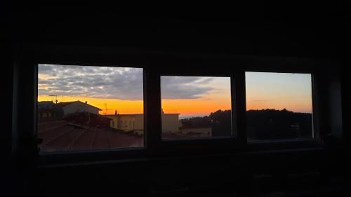 einen Blick auf den Sonnenuntergang von einem Fenster aus in der Unterkunft La Terrazza sul Golfo dei Poeti tra Lerici e le Cinque Terre in Pitelli