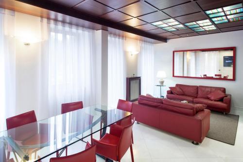 a living room with a glass table and red chairs at Verona apt.65 in Verona