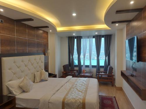 a bedroom with a large bed with a large window at Hotel Sikkim Legend in Gangtok