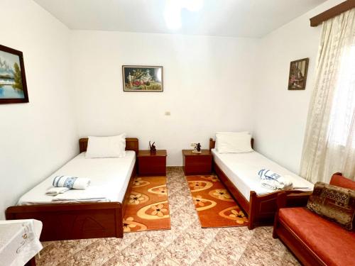 een kamer met 2 bedden en een bank bij Hajdini Apartament in Sarandë