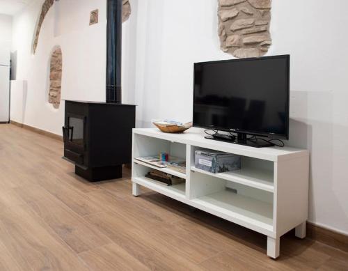 a white entertainment center with a tv and a fireplace at Casa Rural Ana Maria Ain in Ahín