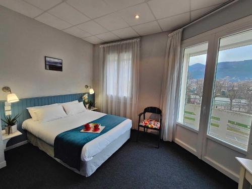 a hotel room with a bed and a large window at Logis Hôtel Cartier in Quillan