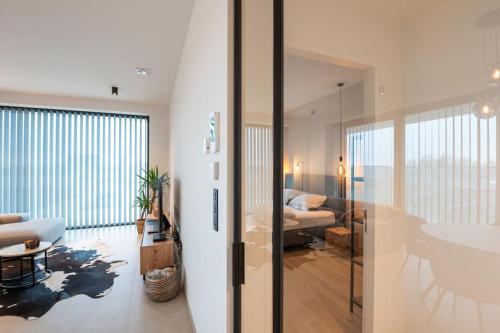 - un salon avec un canapé, un lit et une table dans l'établissement Prachtig appartement met zwembad en fitness, à Ostende