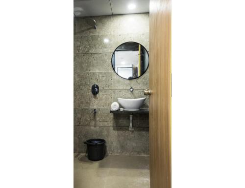 a bathroom with a sink and a mirror at Hotel Saarthi Inn, Surat in Surat
